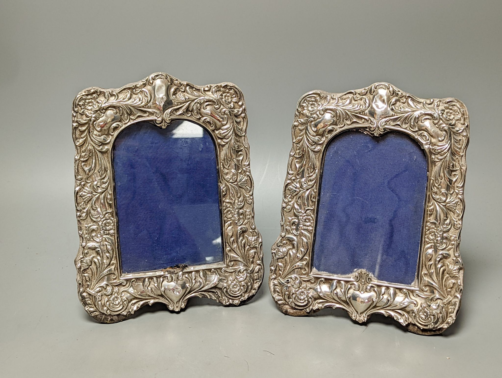 A pair of Edwardian repousse silver mounted photograph frames, Sydney & Co, Birmingham, 1902, 22.5cm (a.f.).